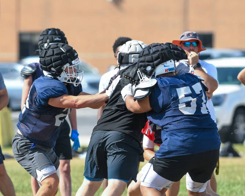 Dekker Zelensk, left, of Oswego helps block during a joint practice against Kaneland on Thursday July 10, 2025, held at Oswego High School.