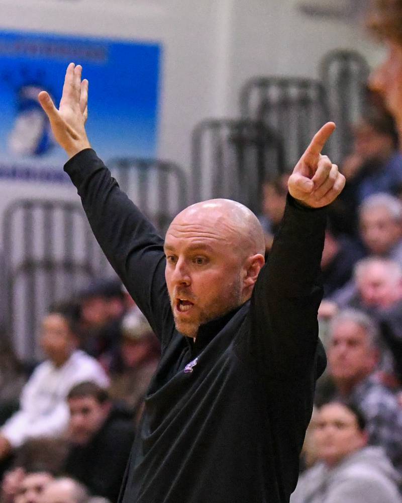 Downers Grove North's head coach James Thomas coaches from the bench area on Saturday Dec. 21, 2024, while traveling to take on crosstown rival Downers Grove held ad Downers Grove South High School.