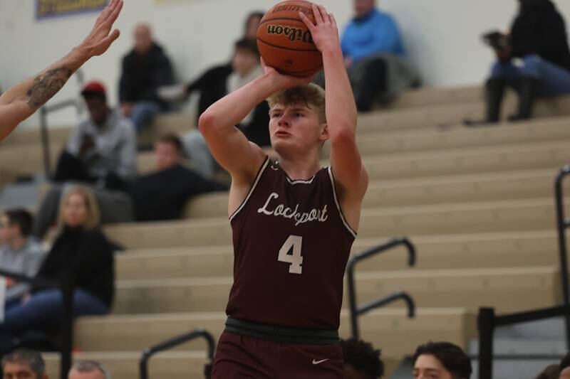 Lockport’s Adam Labude puts up the three point shot against Minooka.