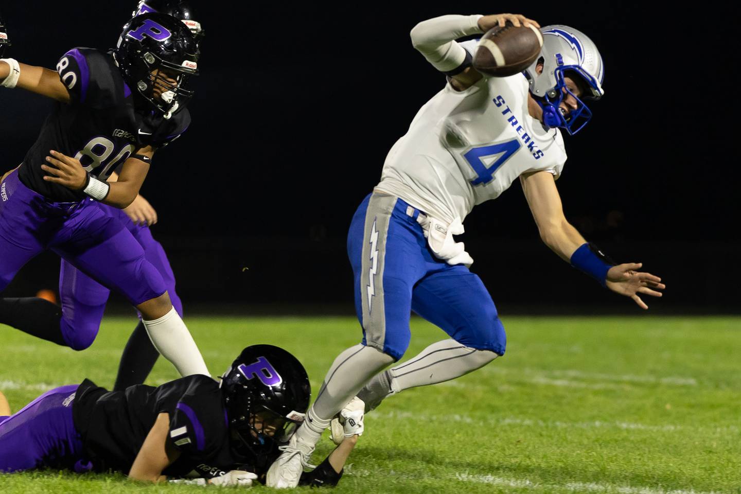 Woodstock quarterback Caden Thompson eludes a Plano defender during Friday's game in Plano.