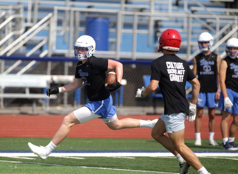 A St. Charles North player runs the ball during a 7-on-7 football game against Yorkville at St. Charles North on Thursday, June 22, 2023.