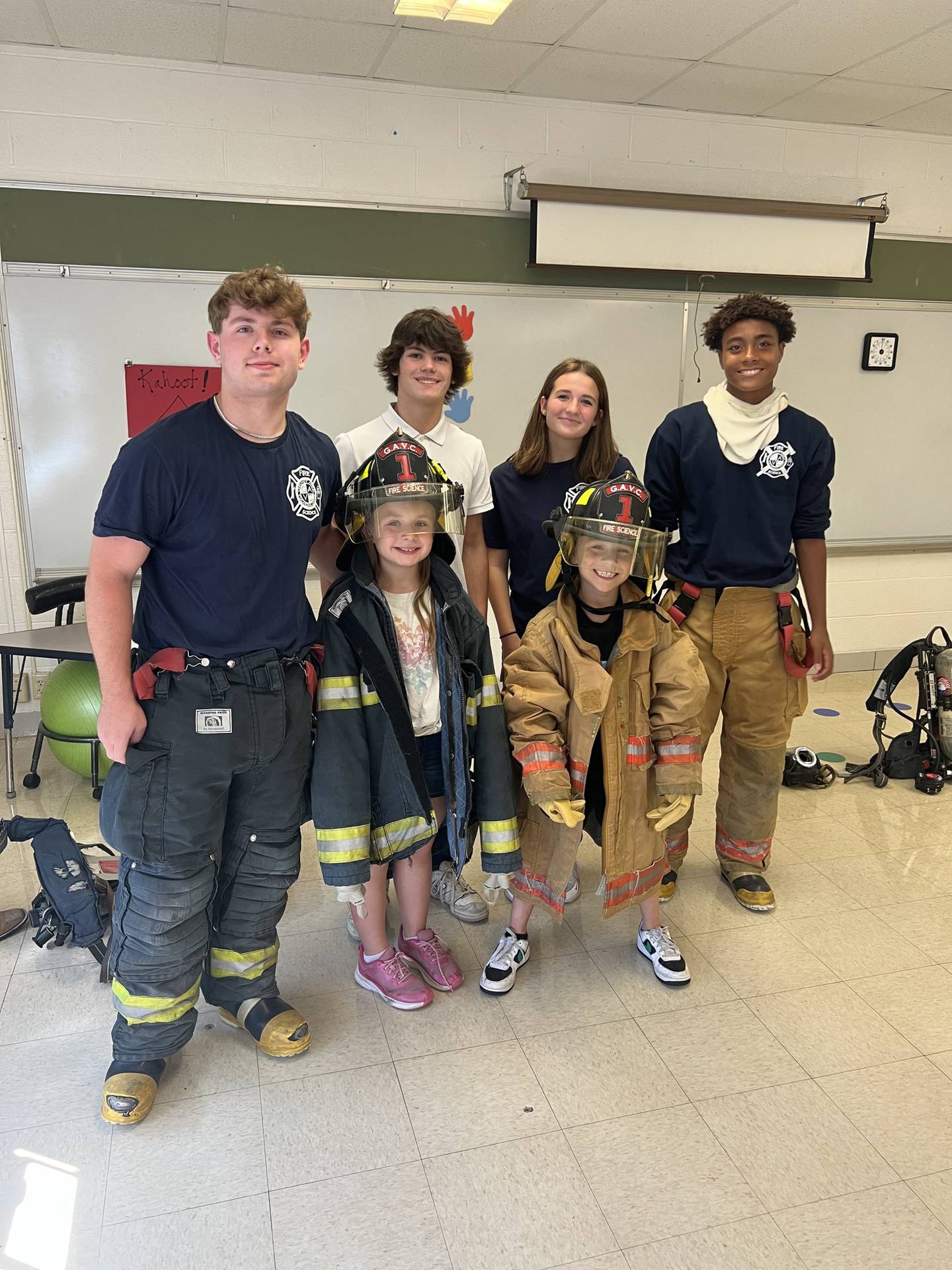 Lucas Pfizenmaier, Brandon Anderson, Sophia Rausa, and Caleb Phillips with two Coal City Elementary students, who got to try on the firefighter's gear.