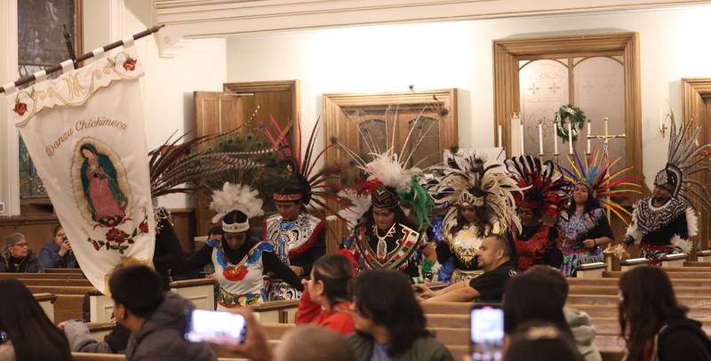 Dancers begin to walk into St. Patrick's Catholic Church to perform during the Lady of Guadalupe vigil Chichimeca dance on Thursday, Dec. 12, 2025 in La Salle. The Chichimeca dance is a vibrant, Indigenous-rooted devotional tradition where dancers (Danzantes) perform to honor the Virgin Mary's appearance to Juan Diego in 1531, symbolizing faith, hope, and cultural fusion, often involving elaborate costumes, feathers, and drumming, leading up to the main Feast Day on December 12th, with celebrations happening globally in parishes.