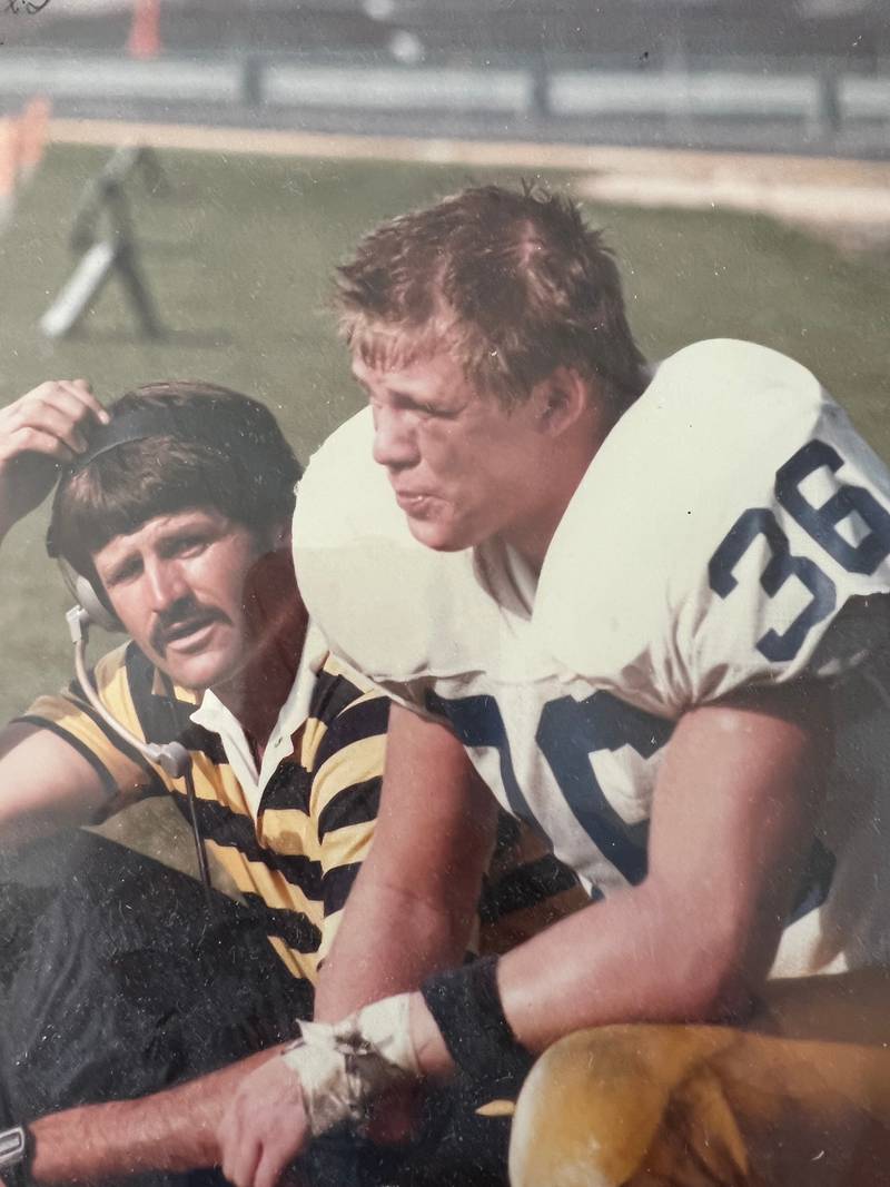 Larry Lokanc (left) speaks to a player on the sideline during a game.