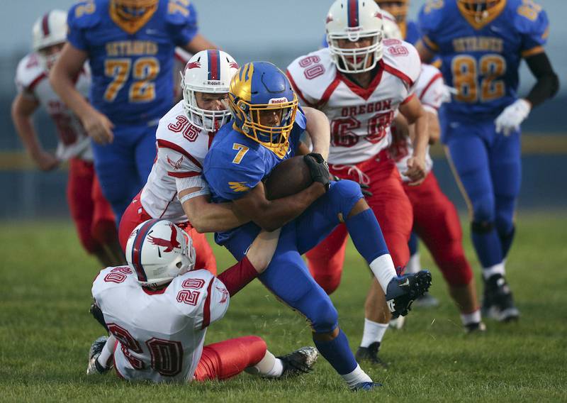 Oregon's Brayton Finch (36) and Jensen Melville (20)  tackle Johnsburg's Alex Peete (7) during the first quarter of their game at Johnsburg High School on Friday August 28, 2015 in Johnsburg, Ill.