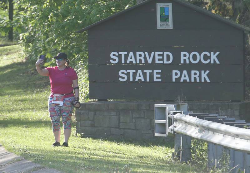 Michelle Wood of McHenry, poses for a selfie in front of the Starved Rock State Park sign in the Starved Rock Country half-marathon on Saturday, May 10, 2025 at Starved Rock State Park.