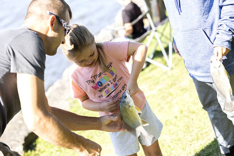 Ava Dale, 5, holds onto her slippery fish Saturday, July 6, 2024 during the Petunia Fest fishing derby.