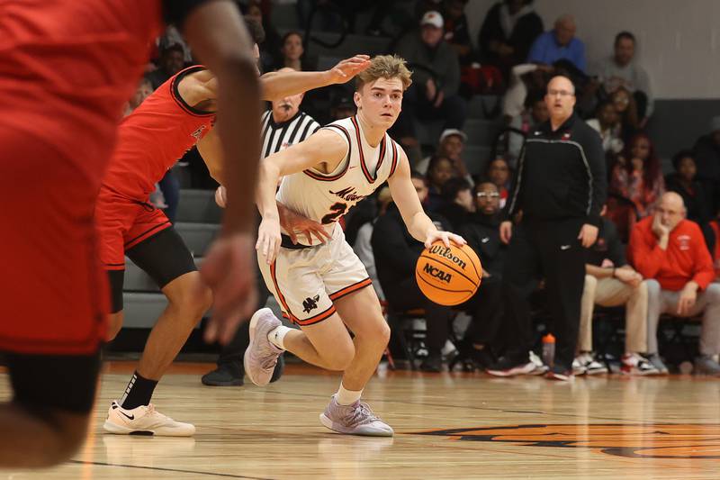Minooka’s Brady Hairaid moves the ball at the top of the key against Bolingbrook on Tuesday, Dec. 17, 2024 in Minooka.