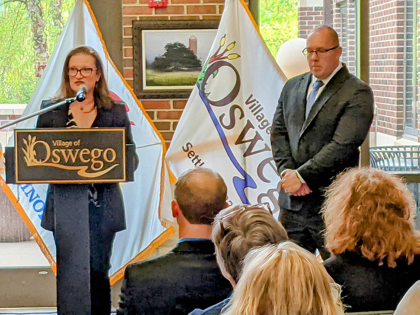 New Oswego Village Trustee Rachelle Koenig speaks to those gathered at a reception and swearing-in ceremony prior to the May 6 Village Board meeting, including Village President Ryan Kauffman, right.