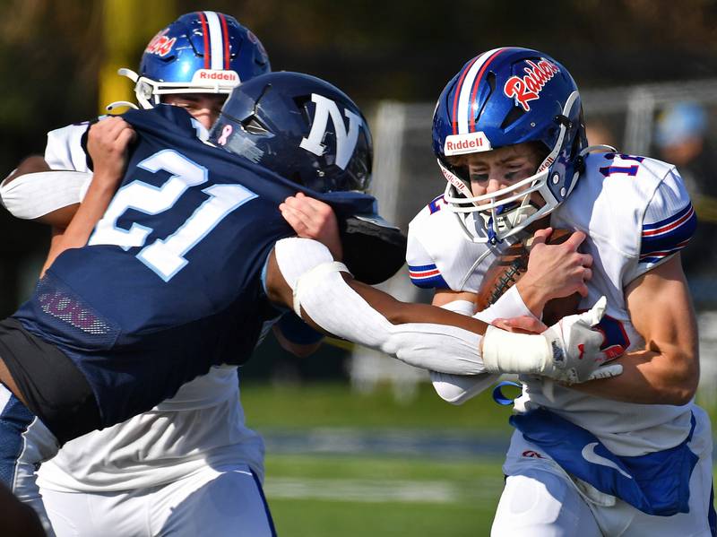 Glenbard South quarterback Michael Champagne (right) tries to scramble past Nazareth's Lesroy Tittle (21) during a Class 5A second round game on Nov. 4, 2023 at Nazareth Academy in LaGrange Park.