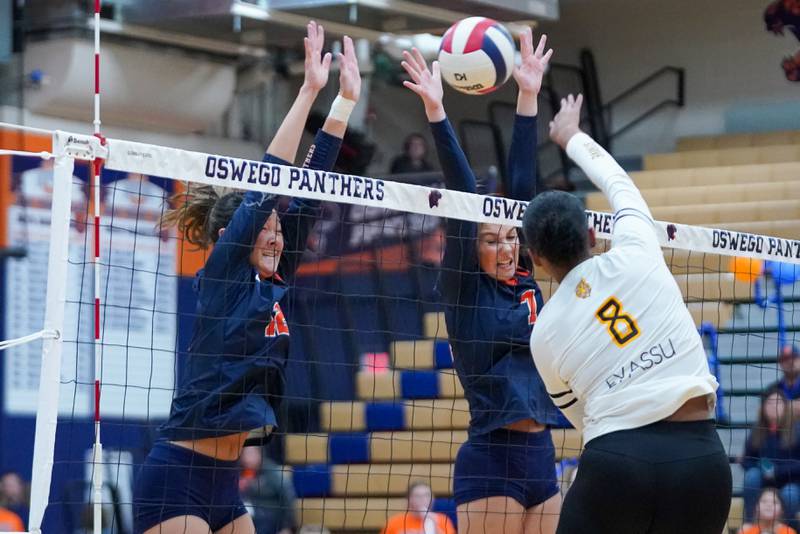 Oswego’s Ava Flanigan (12) and Oswego’s Hannah Herrick (7) defend the net against a kill attempt by Joliet West's Eden Eyassu (8) during a volleyball match at Oswego High School on Thursday, October 24, 2024.