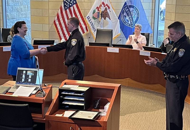 Montgomery Village Trustee Theresa Sperling, left, congratulates Kevin J. Karner, after she swore-in Karner as a Montgomery Police officer during a Village Board meeting at Village Hall on Monday, April 10, 2023. Applauding Karner are Village Administrator Jeff Zoephel, seated, and Police Chief Phil Smith, right.
