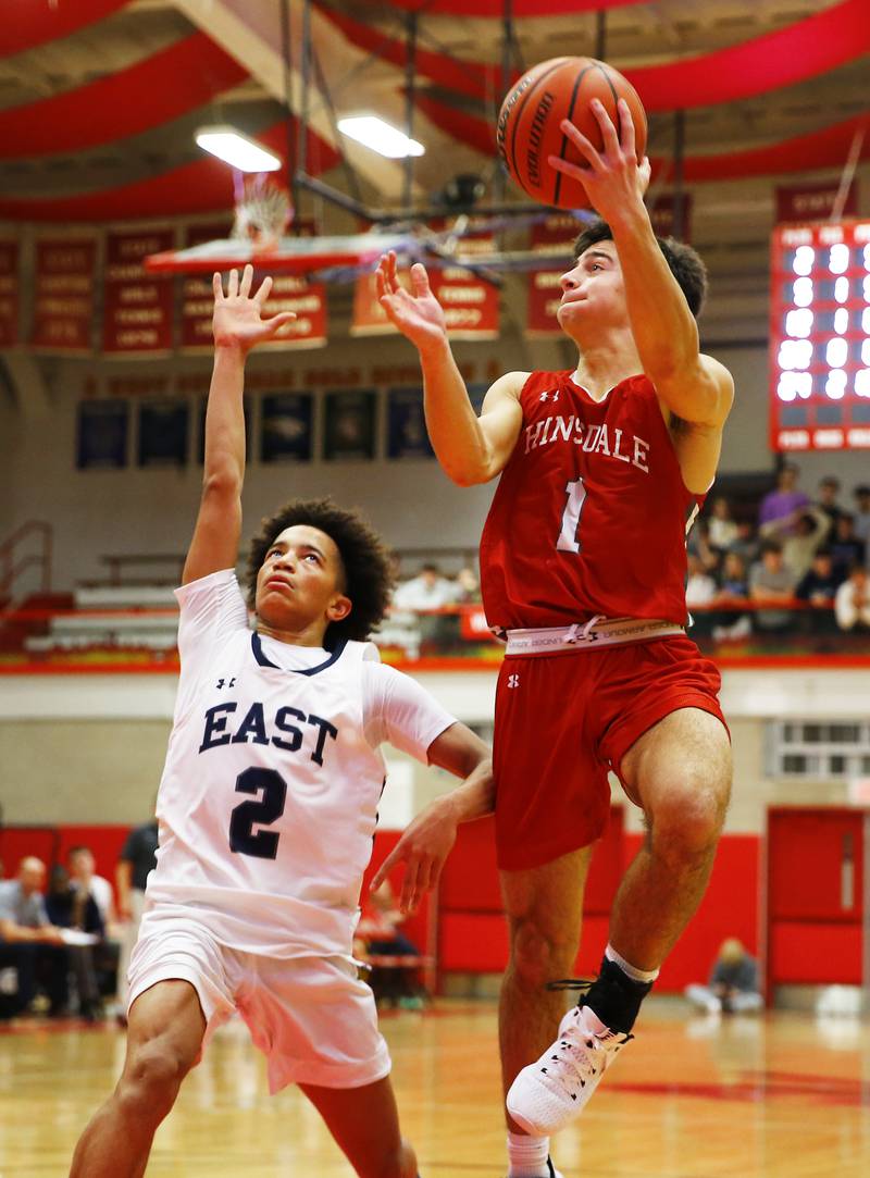 Oswego East's Bryce Shoto (2) attempts to stop Hinsdale Central's Evan Phillips (1) during the Hinsdale Central Holiday Classic championship game between Oswego East and Hinsdale Central high schools on Thursday, Dec. 29, 2022 in Hinsdale, IL.