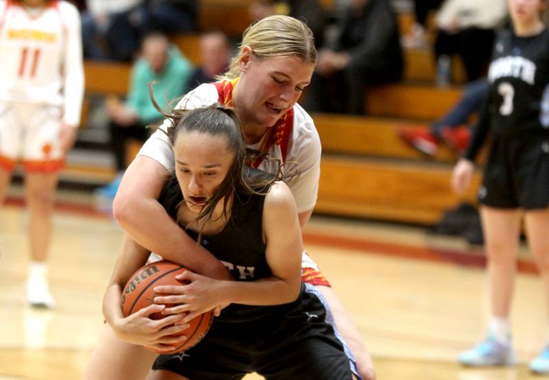 St. Charles North’s Laney Stark holds onto the jump ball away from Batavia’s Sarah Hecht during a game at Batavia on Thursday, Jan. 12, 2023.