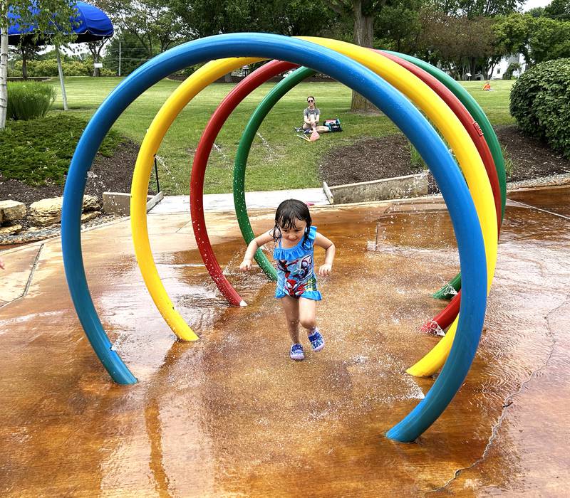 Adiline Nolasco, 4, of Oregon, runs through one of the features at Oregon Park District's Splash Pad on Tuesday, June 4, 2024. The park district hosted a pop-up and play event at Oregon Park West during the afternoon complete with a bubble machine and various types of water guns. The Splash Pad is located next to the shelter and playground at Park West.