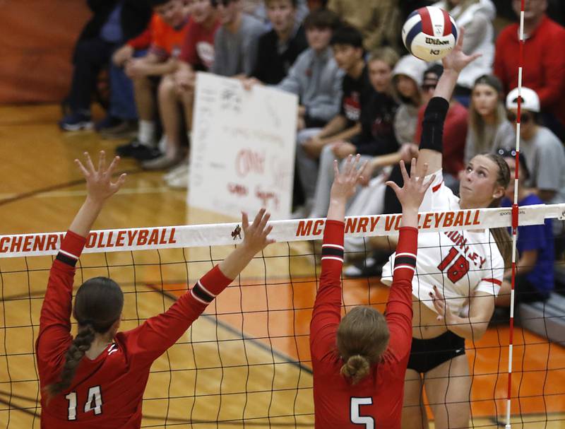 Huntley's Sienna Robertson (right) tries to hit the ball through the block of Mundelein's Lucy Heikes (left) and Norah Emso (center) during an IHSA Class 4A McHenry Sectional volleyball match on Tuesday, Nov. 5, 2024, at McHenry High School Freshman Campus.