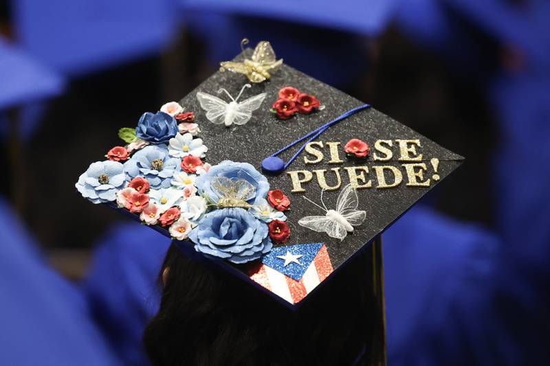 A graduate customizes their hat at the Joliet Central Class of 2023 Commencement Ceremony on Saturday, May 20, 2023, in Joliet.