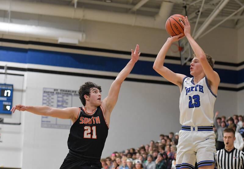 St. Charles North's Luke Holtz (23) shoots over Wheaton Warrenville South Marco Gonzalez (21) during a game on Friday, December 2, 2022.