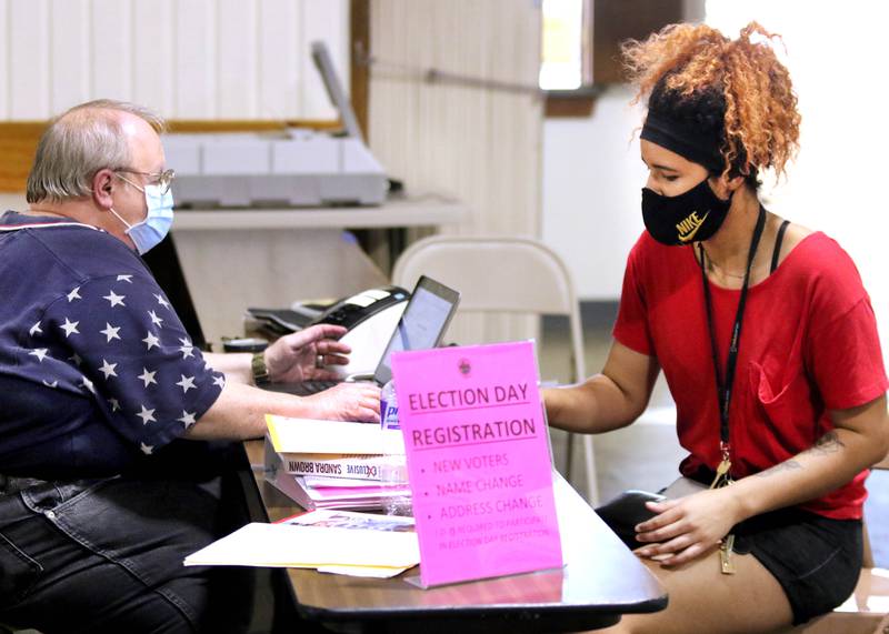 Election judge Steve Nemeth registers Peyton Greene to vote prior to casting her ballot Tuesday at the polling place inside the Westminster Presbyterian Church on Annie Glidden Road in DeKalb.