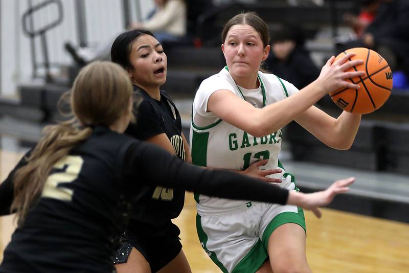 Crystal Lake South's Gaby Dzik (right) tries to split the defense of Grayslake North's Ashlyn Stoneham (left) and Mia Leilani Gumapas (center) during a Northern Illinois Holiday Classic semifinal girl basketball game on Tuesday, Dec. 16, 2025, at McHenry High School.