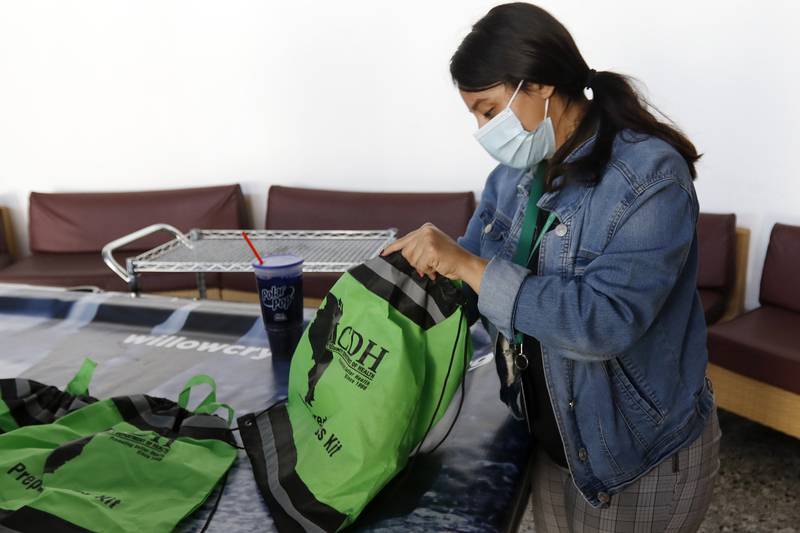 Rocio Nevarez, a community health worker for the McHenry County Department of Health, goes through a bag of supplies that includes face masks, hand sanitizers, a rescue blanket and first aid kit. The bags were available for clients during an Empower Shower event at Willow Crystal Lake on Friday, Aug. 20, 2021, in Crystal Lake. The event gathers multiple agencies with resources to help the homeless.