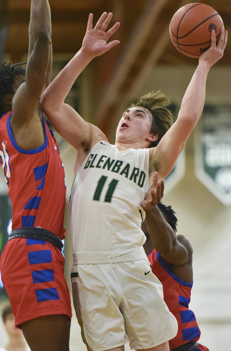 Glenbard West’s Logan Brown puts up a shot against Glenbard South’s Cam Williams in a boys basketball game in Glen Ellyn on Monday, November 21, 2022.