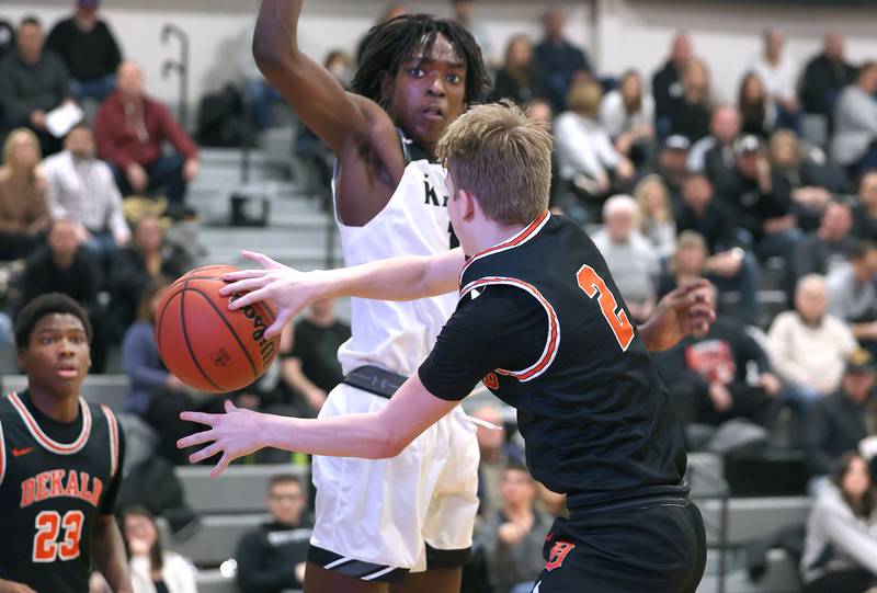 DeKalb's Sean Reynolds passes the ball around Kaneland's Freddy Hassan to an open Davon Grant for an easy dunk during their game Tuesday, Jan. 24, 2023, at Kaneland High School.