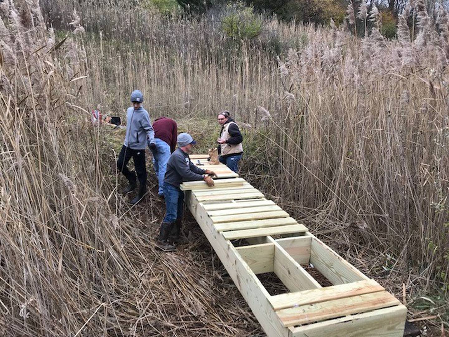 Cooper Vaske and volunteers from Boy Scout Troop 123 work on a bridge at Rotary Park in La Salle. Vaske said he and his Troop spent more than 100 hours of time volunteering to build the bridges for the disc golf course.