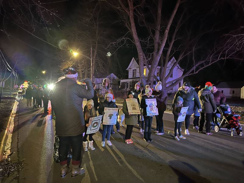 The winners of a holiday coloring contest walk in the 23rd annual Jingle Bell Parade during the Genoa Area Chamber of Commerce's annual Celebrate the Season holiday event on Dec. 6, 2024, in downtown Genoa.