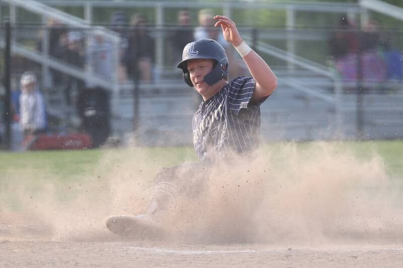 Lemont’s Conor Murray slides home safely on a sacrifice fly ball against Hinsdale South on Wednesday, May 24, 2023, in Lemont.