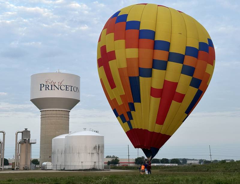 A hot air balloon lands next to the.City of Princeton water tower on Sunday, Sept. 10, 2023 for the 52nd annual Homestead Festival.