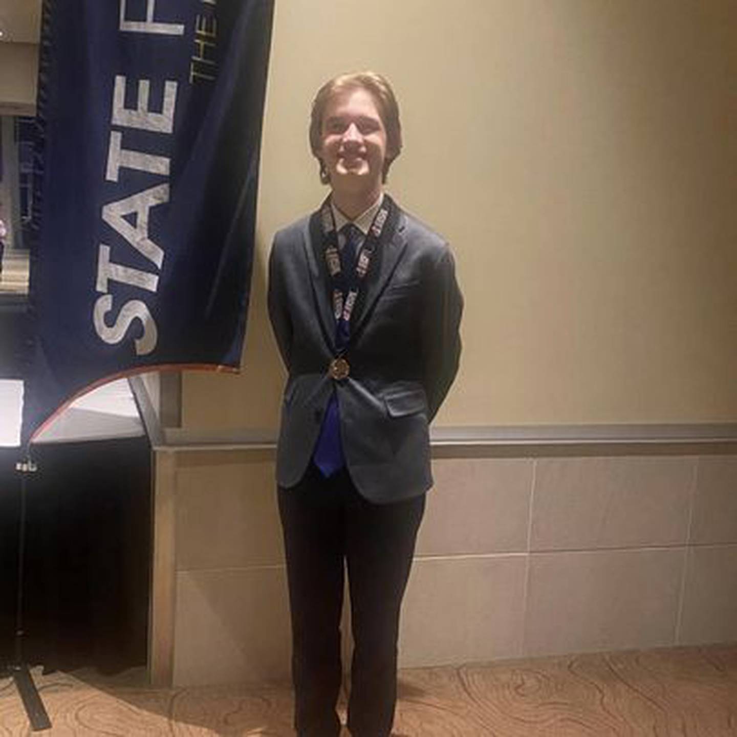 Liam Eber shows his 7th place IHSA State Finalist medal in Original Comedy