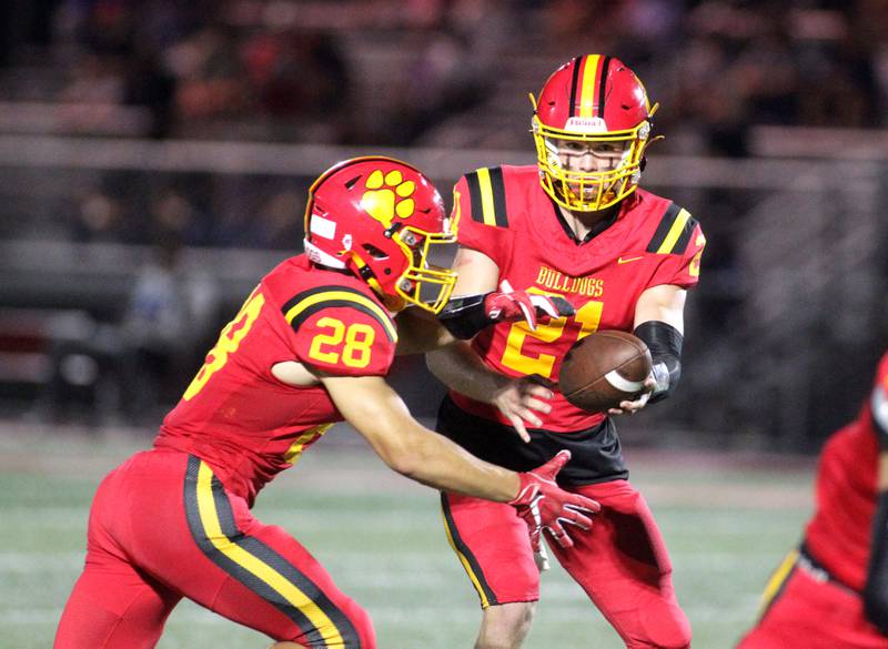 Batavia quarterback Ryan Boe hands the ball off to Nathan Whitwell during the season-opener against Phillips in Batavia on Friday, Aug. 25, 2023.