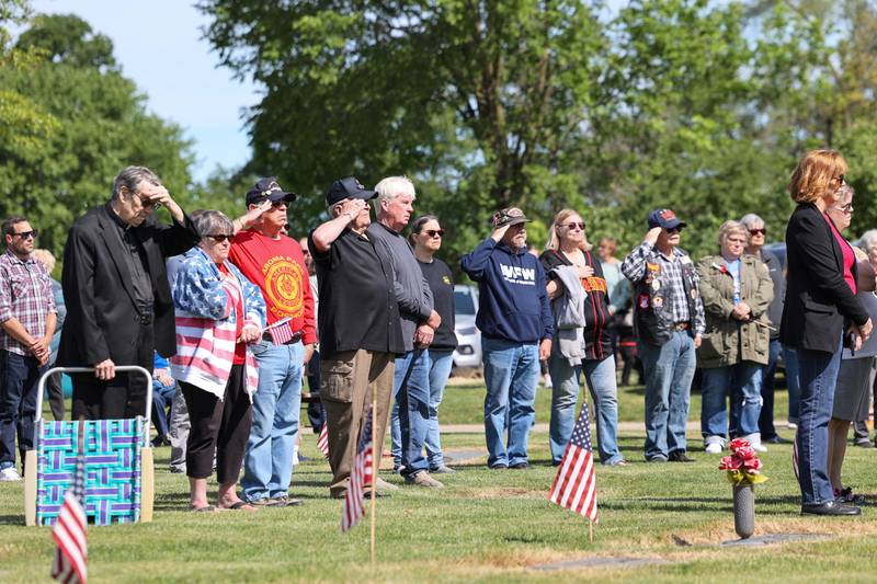 Veterans salute alongside over 100 attendees during a ceremony dedicated to the late John Kirnbauer, a veteran whose ashes went unclaimed for five years, on Monday, May 26, 2025, at Kankakee Memorial Gardens.
