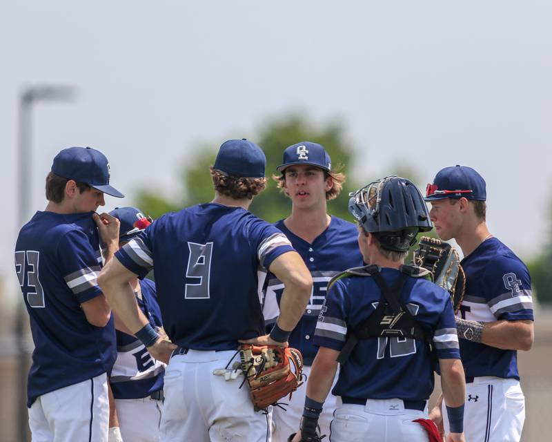 Oswego East's Griffin Sleyko (21) has a conference on the mound during Class 4A Romeoville Sectional final game between Oswego East at Oswego.  June 3, 2023.