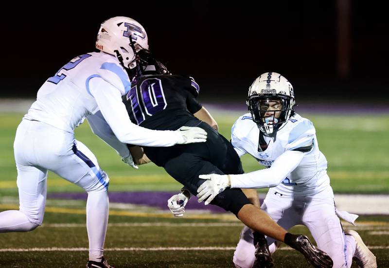 Prospect's Caden Moran (2) and Anthony D'Angelo (1) tries to wrap up Downers Grove North's Oliver Thulin (10) during the IHSA Class 7A playoff football game Friday, Oct. 31, 2025 in Downers Grove.