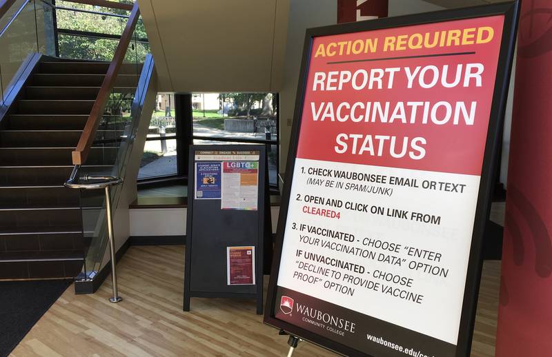 A sign in Waubonsee Community College's  Bodie Hall reminds students, faculty and visitors to report their COVID-19 vaccination status.