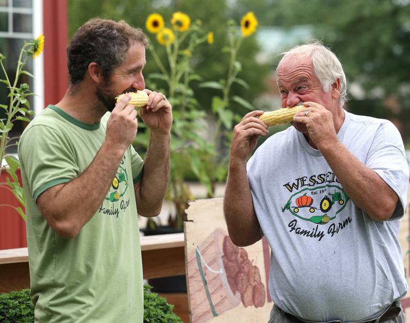 Wessels' Family Farm owners Rob Wessels (right) and his son Brandon enjoy some of their sweet corn Tuesday, Aug. 19, 2025, at Wessels' Family Farm Market in DeKalb. They are preparing to be a big part of  this weekend’s Corn Fest.