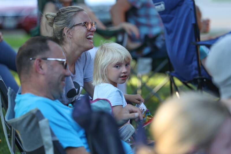 Kallie Dzielawa, 4-years old, enjoys an improv scene with her parents Andy and Katie at the GreenRoom Improv show hosted by the Morris Library at Goold Park on Friday, Aug. 11, 2023 in Morris.