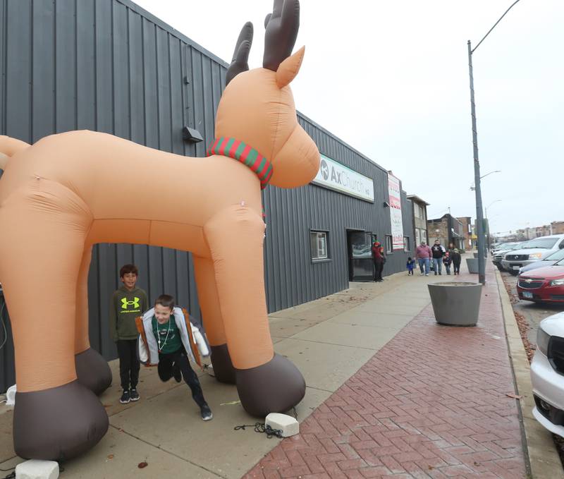 Kids run under a giant inflatable Rudolph during the Miracle on First Street event on Saturday, Dec. 2, 2023 in La Salle.