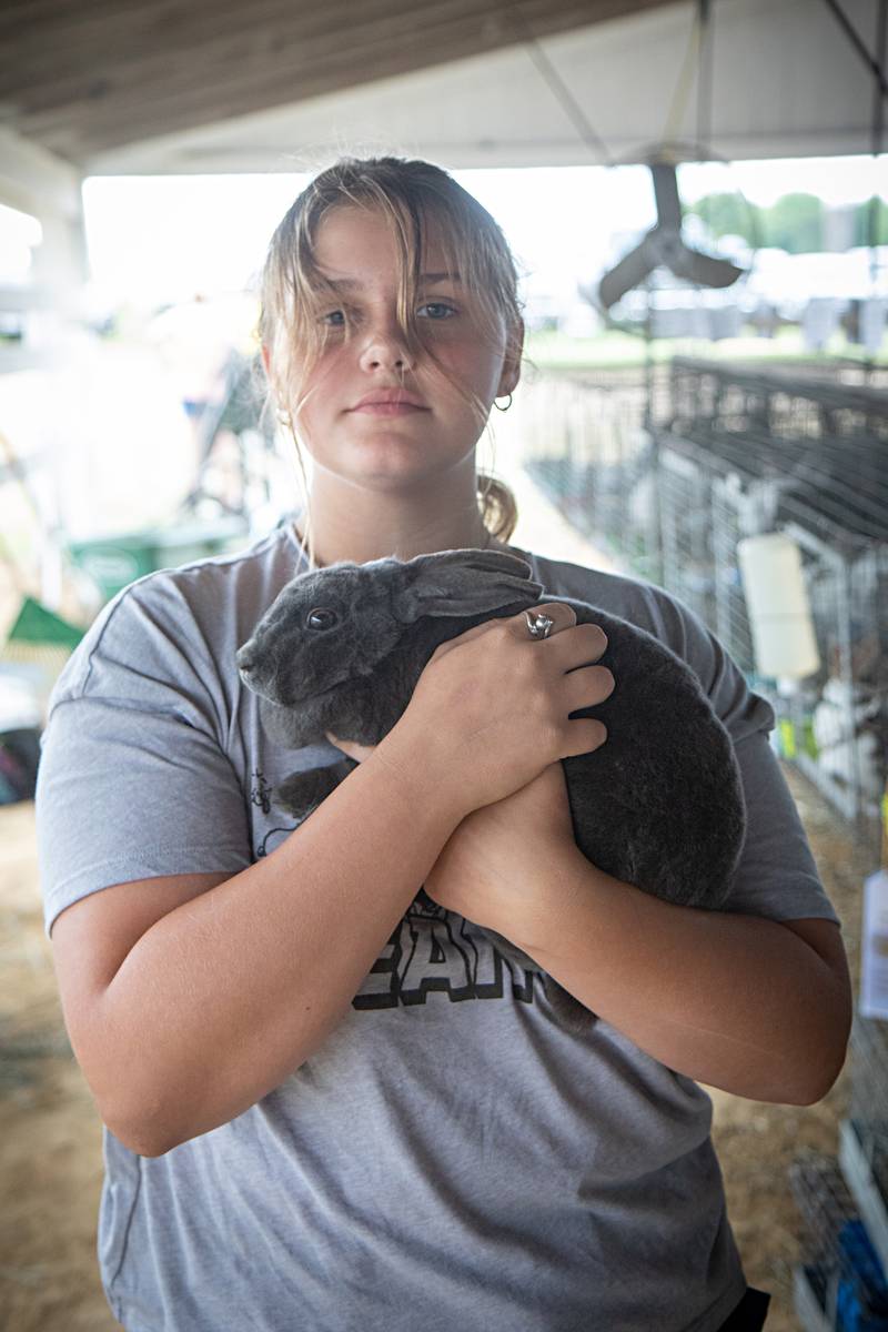 Angel White holds her sister Dakota's grand champion Mini Rex bunny, Totoro, Saturday, July 29, 2023 at the Lee County 4H fair.