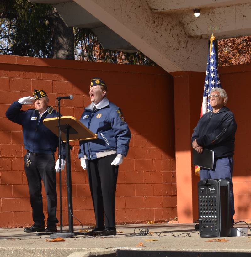Theresa Heffelfinger sings the national anthem Saturday during a Veterans Day observance in Rock Falls' Veterans Park while Darrell Mattson (left) and Mayor Rodney Kleckler look on.