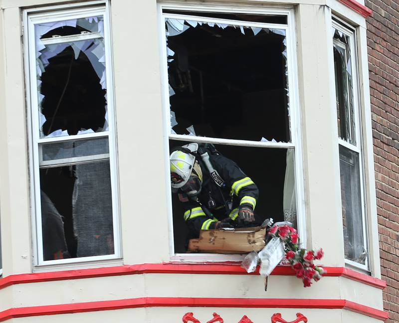 Utica fire chief Ben Brown throws chard debris out of a second story apartment building that caught fire at 201 North Main Street on Monday, Aug. 14, 2023 in Ladd.