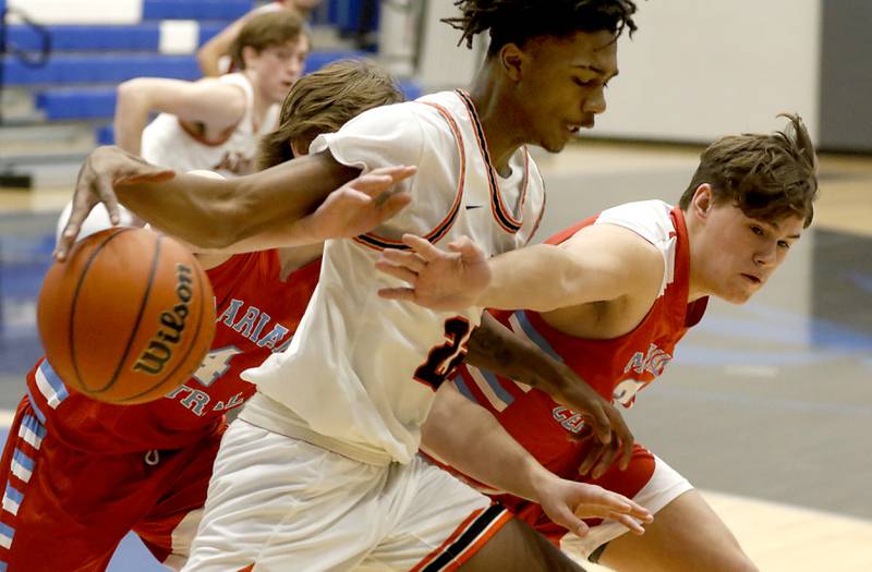 DeKalb's Darell Island tries to control as loose ball as Marian Central's Cale McThenia reaches for the ball during a Central High School’s Dr. Martin Luther King, Jr., Boys Basketball Tournament game Friday, Jan. 13, 2023, at Central High School in Burlington.