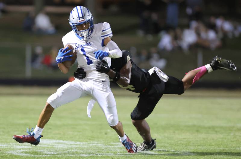Woodstock's Charles Gilmore tries to pull away from Sycamore's Tyler Curtis during their game Friday, Sept. 8, 2023, at Sycamore High School.