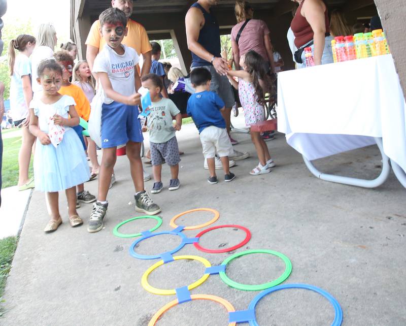 Kids play a ring toss game during the National Night Out event on Tuesday, Aug. 1, 2023 at Zearing Park in Princeton.