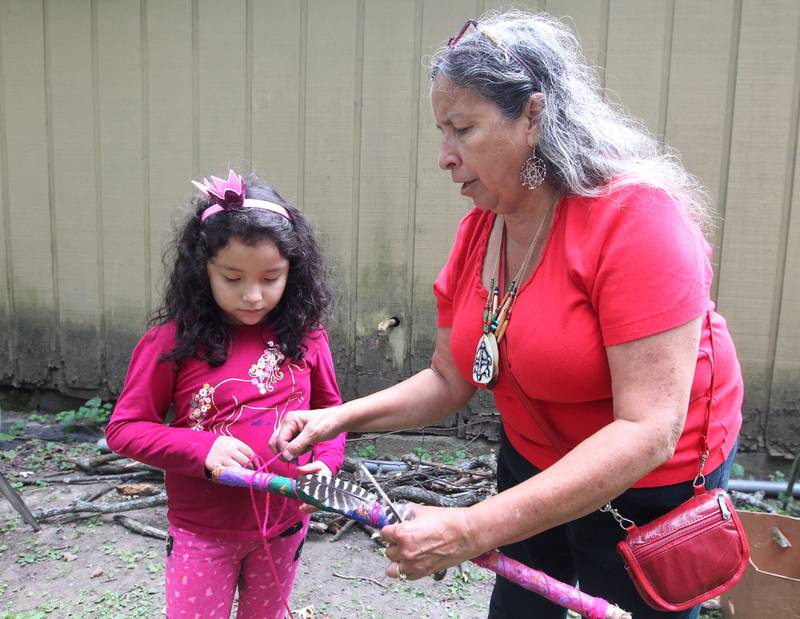 Aurora Toto, 6, helps her aunt, Julie Martinez Bieschke, both of Kenosha, Wis., wrap a talking stick with a feather during the 30th Annual Potawatami Trails Pow-Wow at Shiloh Park on Saturday, August 26th in Zion. 
Photo by Candace H. Johnson for Shaw Local News Network