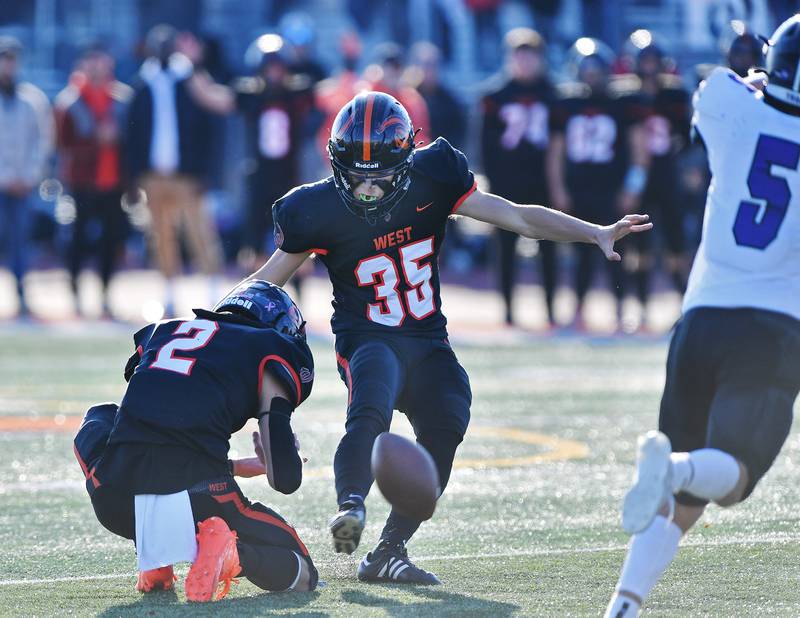 Lincoln-Way West kicker Zach Hermanson (35) kicks a 44 yard field goal out of the hold of Braden Erwin (2) during an IHSA Class 7A quarterfinal game against Lincoln-Way West on Nov. 11, 2023 at Lincoln-Way West High School in New Lenox.