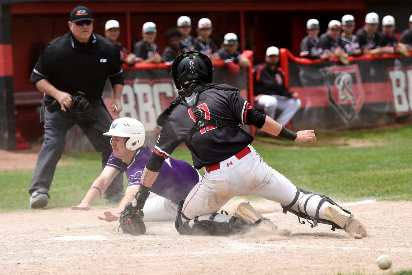 Manteno's Andrew Norred, left, dives into home as the ball gets away from Bradley-Bourbonnais catcher Cayden Arbour during a game at Bradley-Bourbonnais Saturday, May 17, 2025.