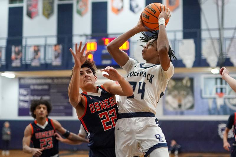 Oswego East's Mason Lockett IV (24) shoots the ball in the post against Oswego’s Luke Roller (22) during a basketball game at Oswego East High School on Saturday, January 11, 2025.